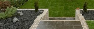Neu angelegte Gartentreppe aus grauem Granit mit Beeten an der Seite